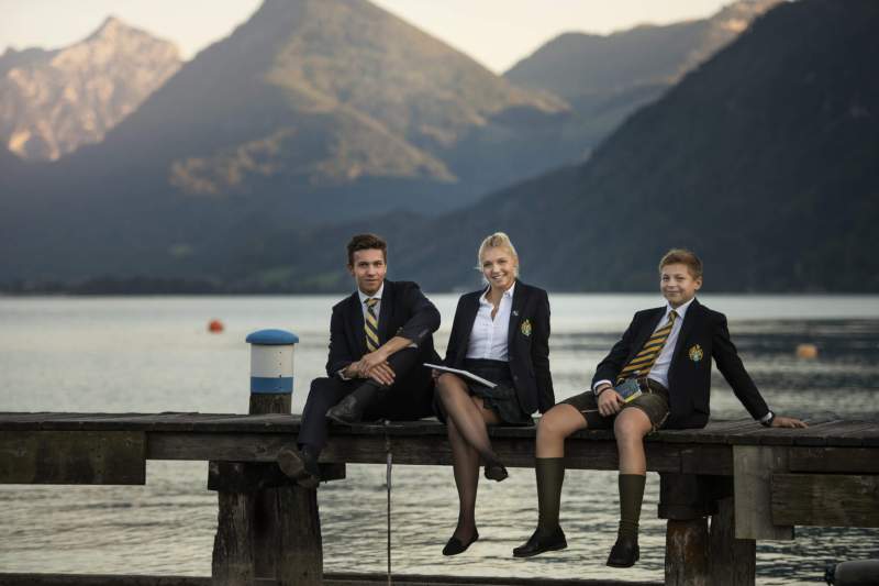 Students sitting on the jetty at Wolfgangsee near St. Gilgen International Day and Boarding School